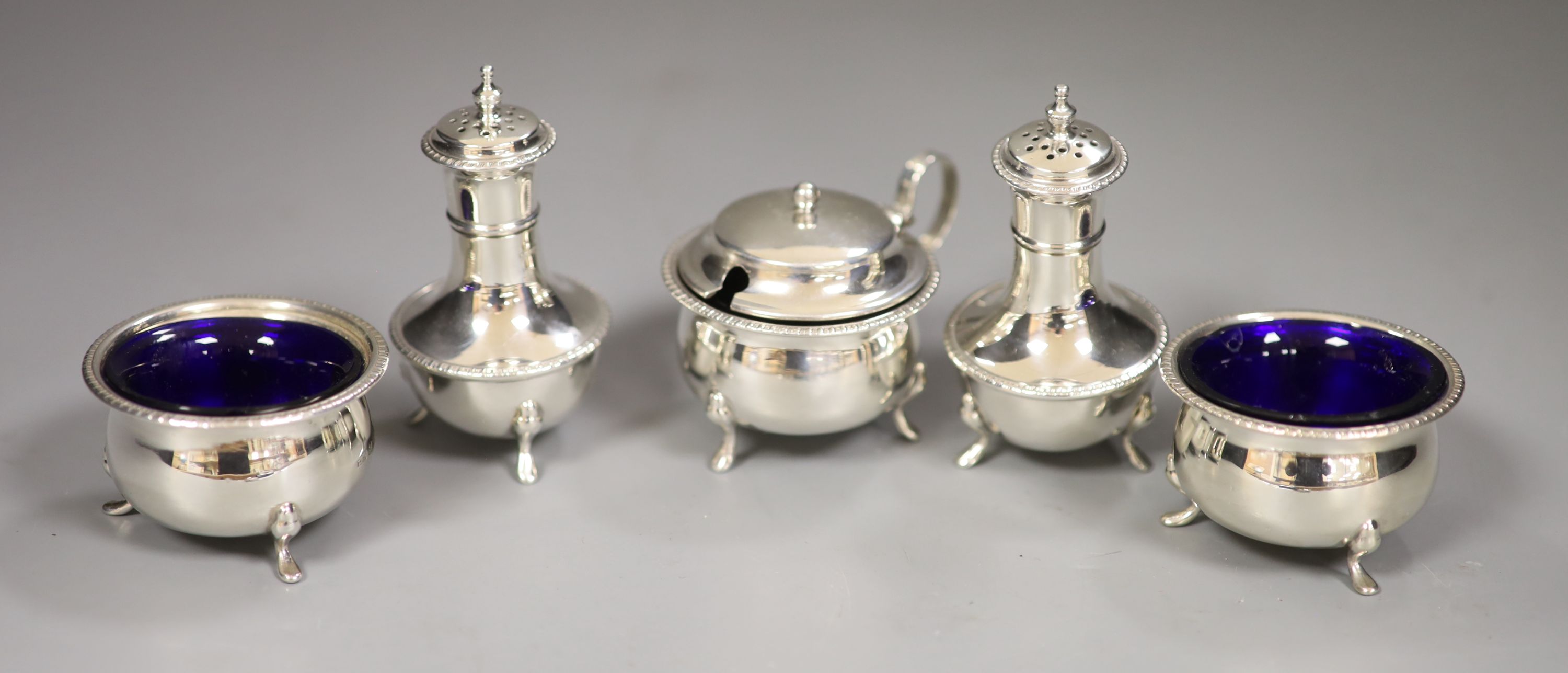 A George V silver three piece condiment set, T.H. Hazlewood & Co, Birmingham, 1918 & a pr of pepperettes.